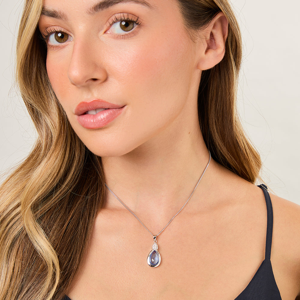 A sterling silver teardrop pendant with blue topaz and cubic zirconia accents, attached to a silver chain-JOOLS by Jenny Brown