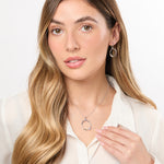 Load image into Gallery viewer, A sterling silver organic circle pendant with three offset graduated cubic zirconia stones, on a silver chain.
