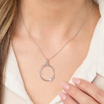 Load image into Gallery viewer, A sterling silver organic circle pendant with three offset graduated cubic zirconia stones, on a silver chain.
