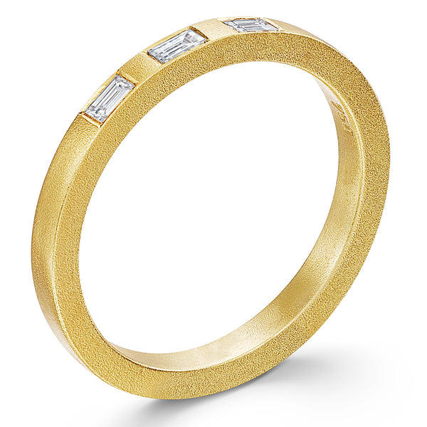 A yellow gold matte finish ring band with three baguette diamonds set on top.
