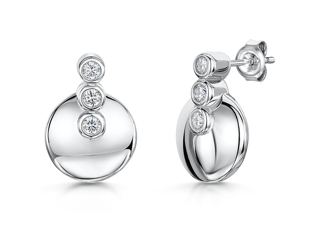 A pair of sterling silver circle earrings with three round cubic zirconia stones in a rhodium-plated finish.